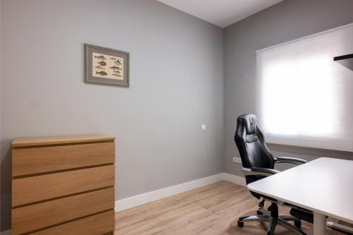 an office with a desk and a chair and a window at Centrico duplex con parking in Tenerife