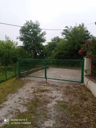 a green fence in front of a tennis court at Vila Oaza mira in Kobiljača