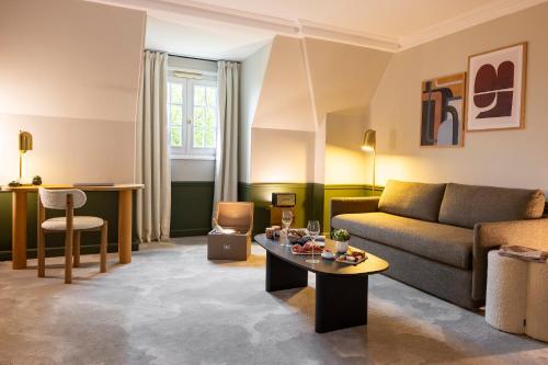 Hostellerie Briqueterie & Spa Champagne في Vinay: غرفة معيشة مع أريكة وطاولة