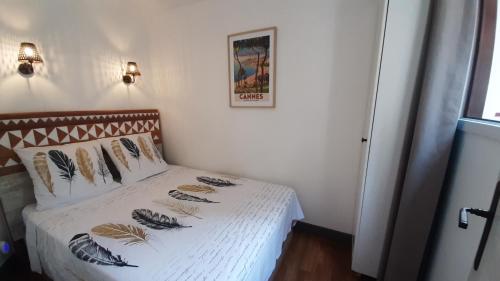 une chambre avec un lit avec des draps blancs et des oreillers dans l'établissement Le Paradis d'Ella, à Cannes