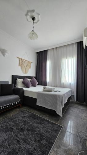a bedroom with a large bed and a couch at Merkez Kumsal Pansiyon in Bodrum City