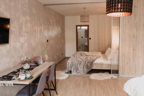 a bedroom with a bed and a table and a desk at Jánsky rezort in Liptovský Ján