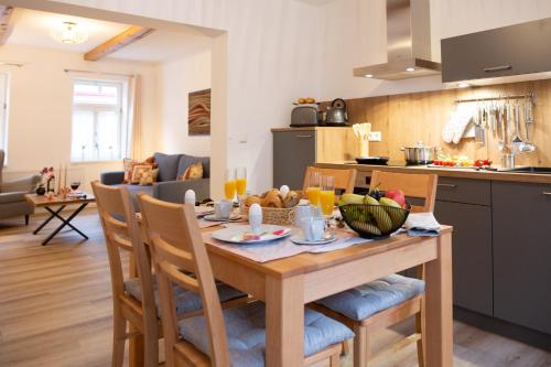 a kitchen and living room with a wooden table with fruit on it at Fachwerkfeeling im gesamten EG-hochwertig neu sanierte Fewo im Heideviertel perfekte Innenstadtlage inklusive Parkplatz in Wernigerode
