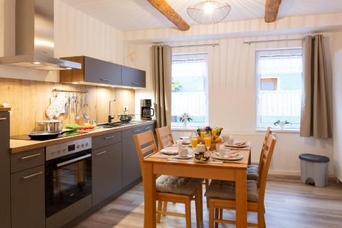 a kitchen with a wooden table and a dining room at Fachwerkfeeling im gesamten EG-hochwertig neu sanierte Fewo im Heideviertel perfekte Innenstadtlage inklusive Parkplatz in Wernigerode