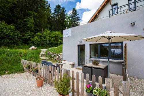 a wooden fence with an umbrella in front of a house at Studio La Résilience, au pied des pistes à Autrans in Autrans