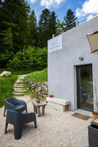 a building with a bench and a chair next to it at Studio La Résilience, au pied des pistes à Autrans in Autrans