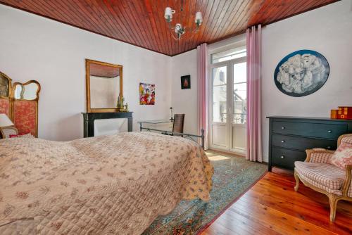 a bedroom with a bed and a window and a chair at Maison Albizia in Le Croisic