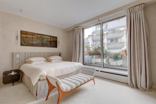 une chambre avec un lit et une grande fenêtre dans l'établissement 671 Suite Bon Marché - Superbe Appartement à Paris, à Paris