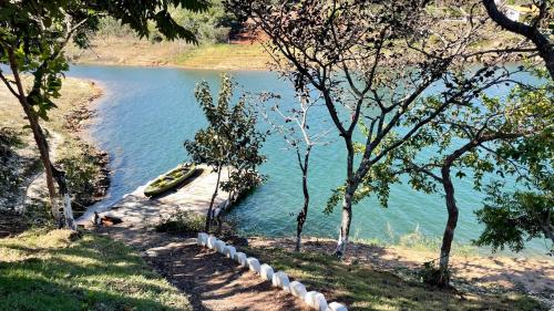 a boat sitting on the shore of a lake at Brisa do Lago Pousada in Capitólio