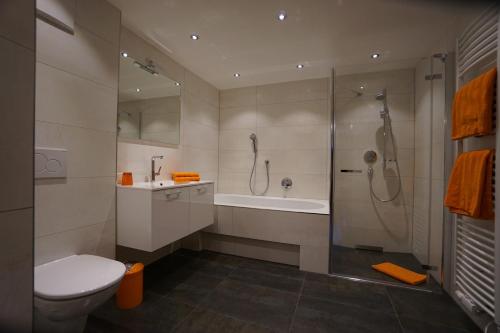 a bathroom with a shower and a toilet and a tub at Ferienwohnung Fam.Maria Geiler in Heinfels