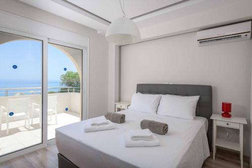 a bedroom with a bed and a balcony with the ocean at Paradise Beach II in Kiotari