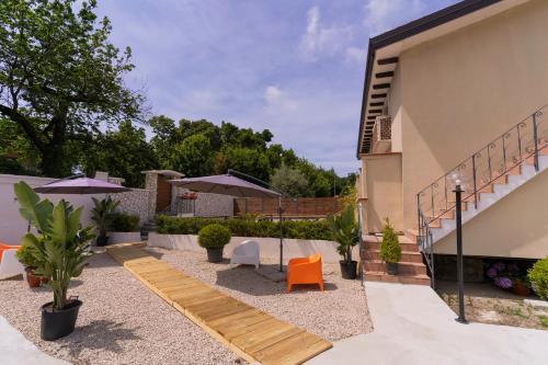 a courtyard with chairs and umbrellas next to a building at Greenlove in Agerola