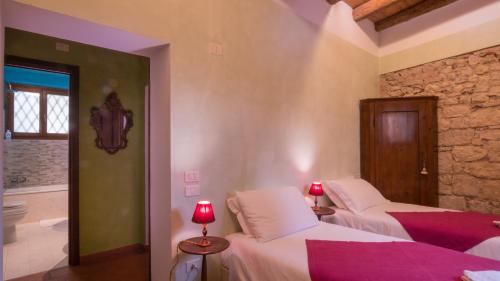 a bedroom with two beds and a bathroom at Villa Betteloni Valpolicella Suites in San Pietro in Cariano