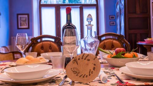 a dining room table with a bottle of wine and food at Villa Betteloni Valpolicella Suites in San Pietro in Cariano