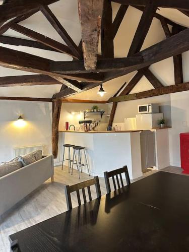 un salon avec une table et des chaises noires dans l'établissement Bel Appart au cœur d Ancenis, Vélos Bienvenue, à Ancenis