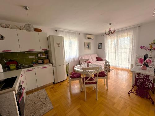 a kitchen and living room with a table and a couch at Apartment Second Home in Tribunj