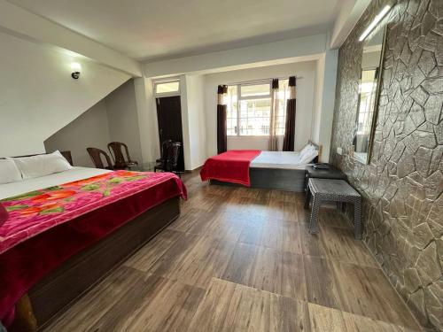 a hotel room with two beds and a table and a bed sidx sidx at Silk Route Resort Aritar in Rhenok
