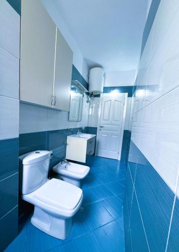 a bathroom with a white toilet and a sink at H-Apartment Lungo Mare in Vlorë