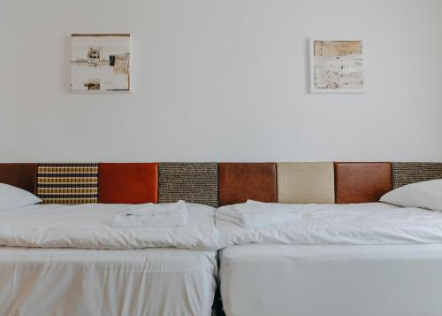 a group of three beds sitting next to each other at Salon Win Wine Bar & Apartments in Jasło