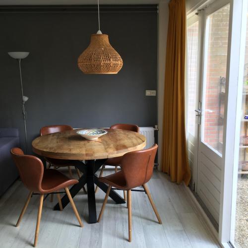 a dining room with a wooden table and chairs at Huize Beemsterlaan in Bergen