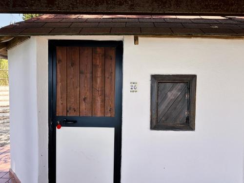 a white shed with a door and a window at Residence Punta Cilento in Pisciotta