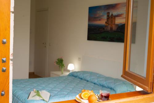 a bedroom with a blue bed and a mirror at Villa Rosa in Castiglione del Lago