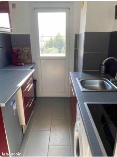 une petite cuisine avec un évier et une fenêtre dans l'établissement Appart 4 couchages proche de la mer, à Canet