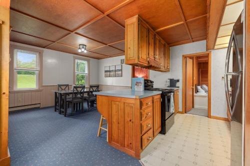 een keuken met houten kasten en een eetkamer bij Entire House within Campground in Mifflinburg