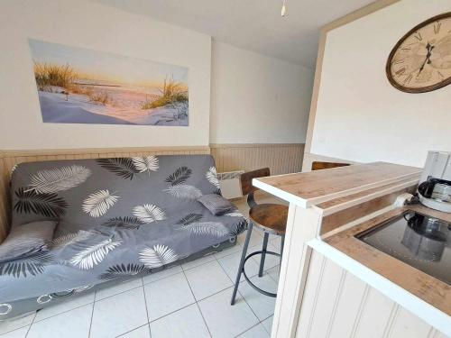un salon avec un canapé et une horloge au mur dans l'établissement Appartement 2 Pièces avec Piscine, Parking Privé et Proche Plage pour 4 Personnes - FR-1-326-820, à Marseillan