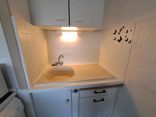 une petite salle de bains avec lavabo et lumière dans l'établissement Appartement 2 Pièces avec Piscine, Parking Privé et Proche Plage pour 4 Personnes - FR-1-326-820, à Marseillan