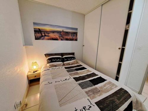 une chambre avec un lit et un tableau au mur dans l'établissement Appartement 2 Pièces avec Piscine, Parking Privé et Proche Plage pour 4 Personnes - FR-1-326-820, à Marseillan