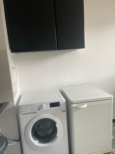 une laveuse et une sécheuse dans une petite pièce dans l'établissement Charmant studio, Créteil L'Échat, à Créteil