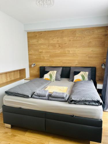 a bedroom with a large bed with a wooden headboard at Apartment Rebeka in Ružomberok