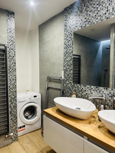 a bathroom with a sink and a washing machine at Apartment Rebeka in Ružomberok