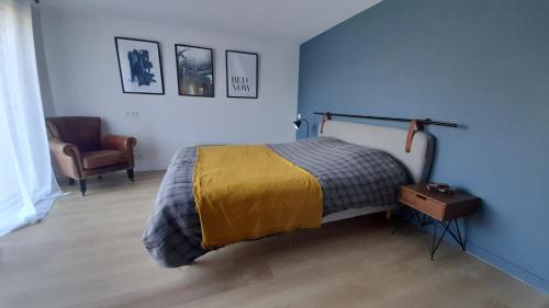 un dormitorio con una cama y una silla en Chambre vue jardin - proche port, en Vannes