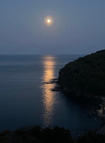 a full moon rising over the ocean at night at Manazuru Marin Hotel in Manazuru