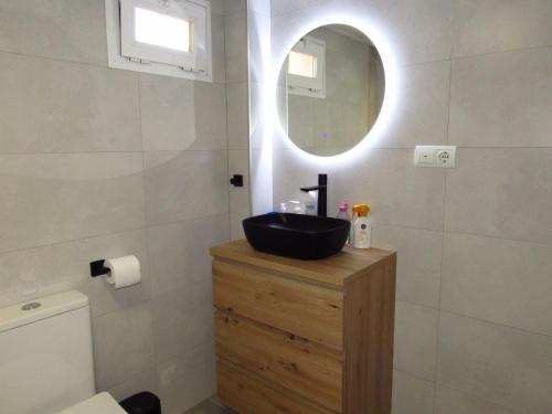 ein Badezimmer mit einem schwarzen Waschbecken und einem Spiegel in der Unterkunft Torreon del Mar Apartment in Benalmádena