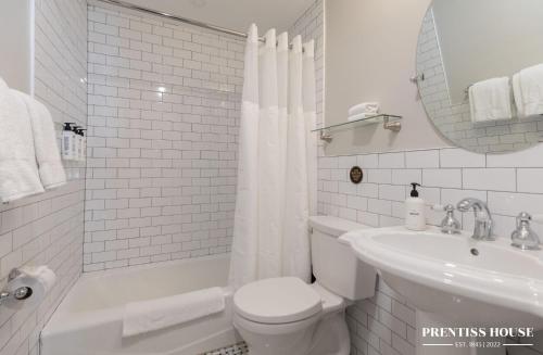 a white bathroom with a toilet and a sink at Prentiss House by Thatch in Cambridge