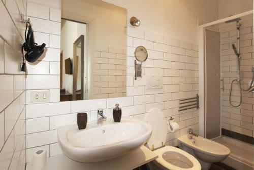 a white bathroom with a sink and a toilet at Flaminia - B&B Tevere Home "Bed your Breakfast" in Rome