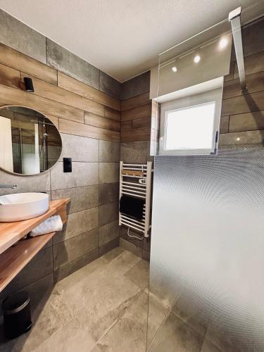 une salle de bain avec un lavabo et un miroir dans l'établissement La Perle de l'Eau - au bord du lac, à Gérardmer