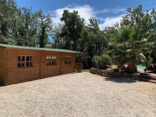 un petit bâtiment en bois dans une allée de gravier dans l'établissement Le Chalet de l'Adrech, à La Garde-Freinet