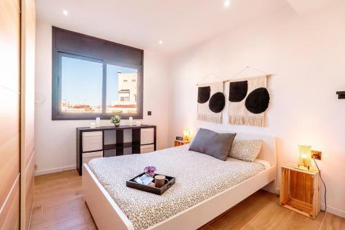 een slaapkamer met een groot bed en een raam bij Penthouse by Unik Vacation in Tarragona