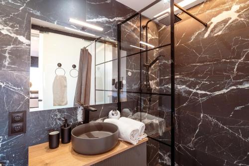 een badkamer met een wastafel en een glazen wand bij Penthouse by Unik Vacation in Tarragona