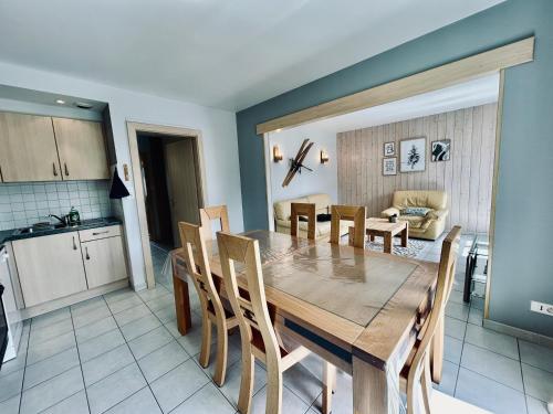 une cuisine et une salle à manger avec une table et des chaises en bois dans l'établissement La Perle de l'Eau - au bord du lac, à Gérardmer