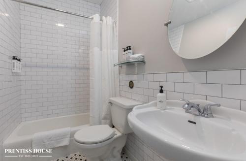 a white bathroom with a toilet and a sink at Prentiss House by Thatch in Cambridge