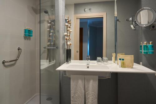 a bathroom with a sink and a shower at Hotel Puerta de Toledo in Madrid