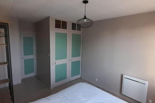 a bedroom with green and white walls and a bed at Maison de village cosy in Saint-Eustache-la-Forêt