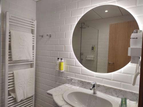 a white bathroom with a sink and a mirror at Hotel Sercotel Cuatro Postes in Avila