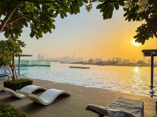 a pool with a view of the city at sunset at Burj Khalifa view & Creek sea view in Dubai