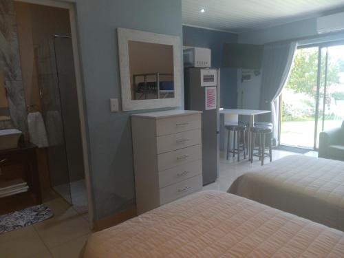 a bedroom with two beds and a dresser with a mirror at SONHOS dreams Self catering Garden Cottages in Bloemfontein